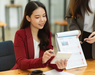 A young asian woman presents data in a meeting