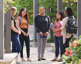 Group of diverse students outside in Reiman Plaza